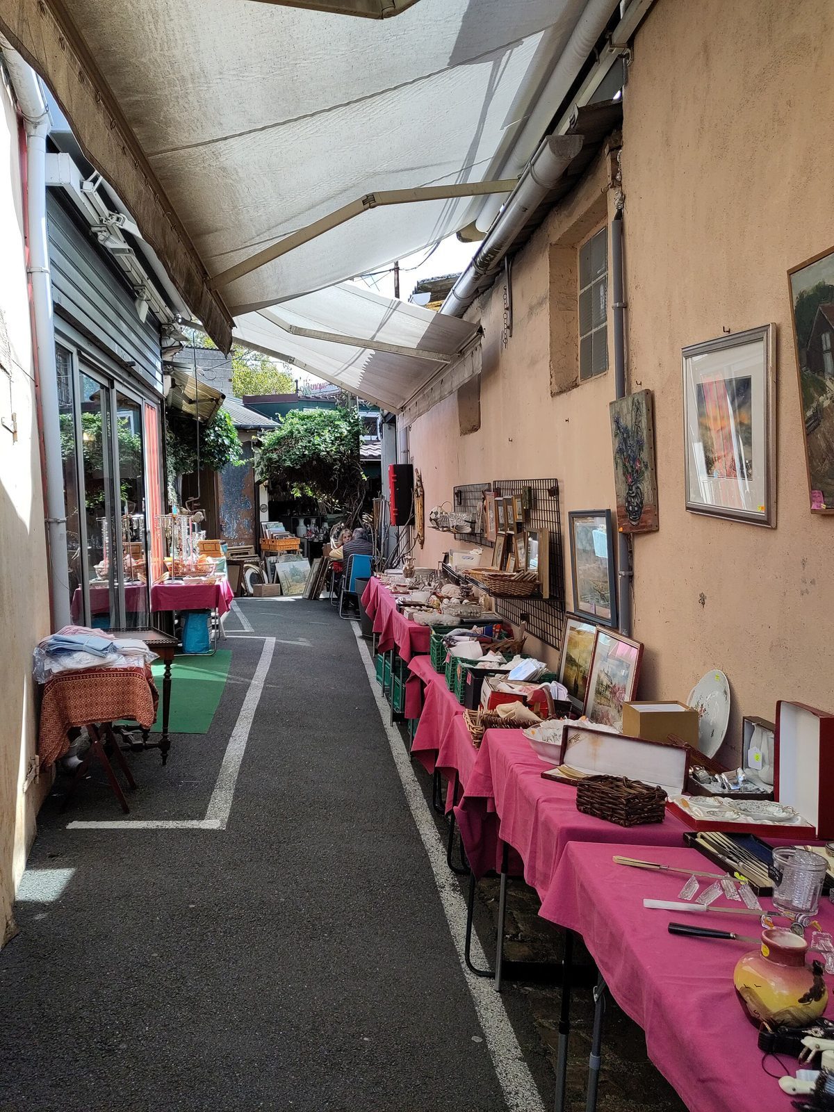 Une allée étroite bordée de stands de brocante aux puces de Saint-Ouen